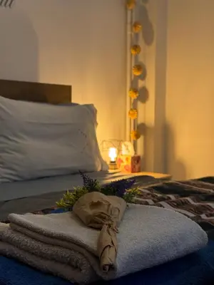 a bed with a towel and flowers on it at Apollo Apartment Athens/Airport in Spáta