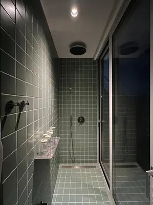 a tiled bathroom with a shower with a glass door at Penthouse with Private Rooftop and Hot Tub in Athens