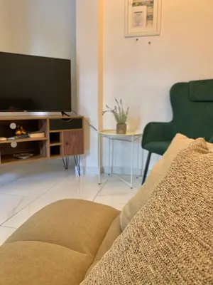 a living room with a flat screen tv and a couch at Gina's cozy home in Athens