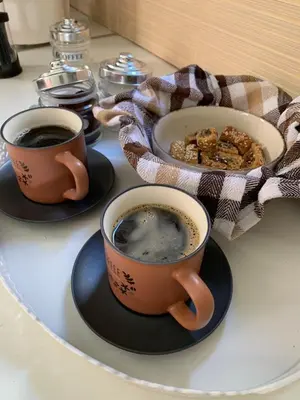 two cups of coffee and a plate of food on a table at Gina's cozy home in Athens