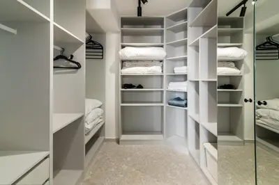 a walk in closet with white shelves and a glass door at Kolonaki Square Central Penthouse in Athens