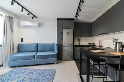 a living room with a blue couch and a kitchen at Kolonaki Square Central Penthouse in Athens