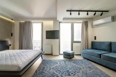 a bedroom with a bed and a couch at Kolonaki Square Central Penthouse in Athens
