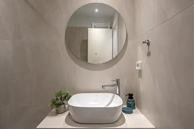 a bathroom with a white sink and a mirror at Acropolis view apt in Koukaki in Athens
