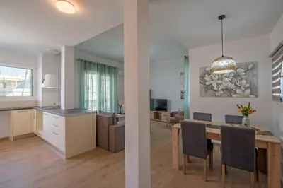a kitchen and living room with a dining room and a dining table at Acropolis view apt in Koukaki in Athens
