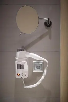 a hair dryer on a wall with a mirror at Hector Luxury Suite in Athens