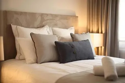 a bed with white pillows and a headboard at Hector Luxury Suite in Athens