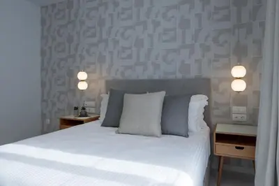a bedroom with a white bed with two tables and two lamps at Azalea Luxury Apartment in Athens