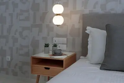 a bedroom with a bed and a nightstand with a lamp at Azalea Luxury Apartment in Athens