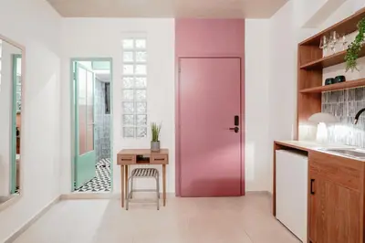 a pink door in a kitchen with a table at Next door Athens in Athens