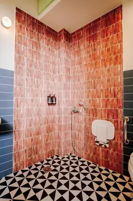 a bathroom with a shower with a tiled wall at Next door Athens in Athens