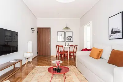 a white living room with a white couch and a table at Comfy 1BR Apartment in Ampelokipoi by UPSTREET in Athens