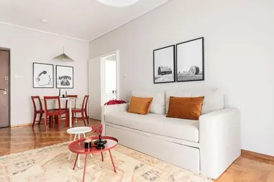 a living room with a white couch and a table at Comfy 1BR Apartment in Ampelokipoi by UPSTREET in Athens