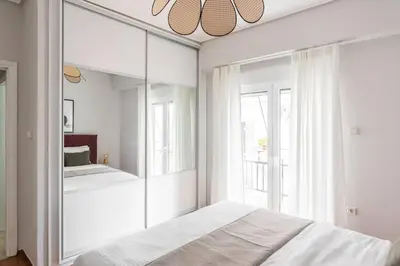a white bedroom with a mirror and a bed at Comfy 1BR Apartment in Ampelokipoi by UPSTREET in Athens