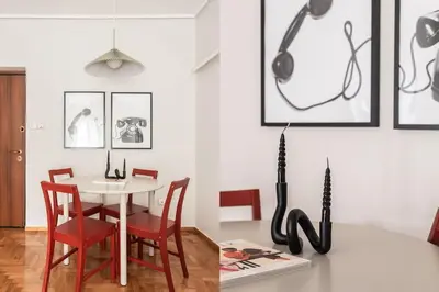 a dining room with a white table and red chairs at Comfy 1BR Apartment in Ampelokipoi by UPSTREET in Athens