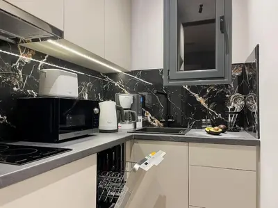 a kitchen with white cabinets and black marble walls at Lucky Central Home #22 VIPGreece in Athens