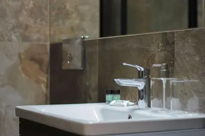 a bathroom sink with a faucet and a mirror at Lucky Central Home #22 VIPGreece in Athens