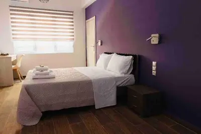 a bedroom with a bed with a purple wall at FKVILLAS-K-1 in Piraeus