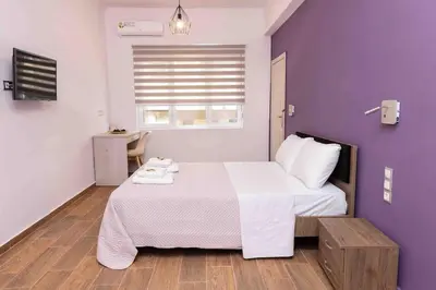 a bedroom with a large bed with a purple wall at FKVILLAS-K-1 in Piraeus