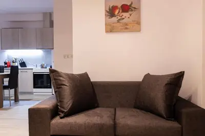 a brown couch in a living room with a kitchen at FKVILLAS-K-1 in Piraeus