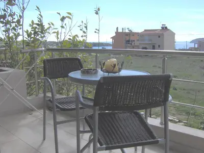 a table and two chairs on a balcony at Sunset at Cape Sounio in Sounio