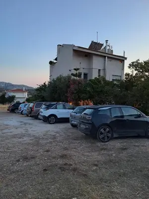 a row of cars parked in front of a building at Sunset at Cape Sounio in Sounio