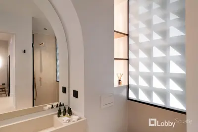 a bathroom with a mirror and a sink at Muse Apartment by LobbySquare in Athens