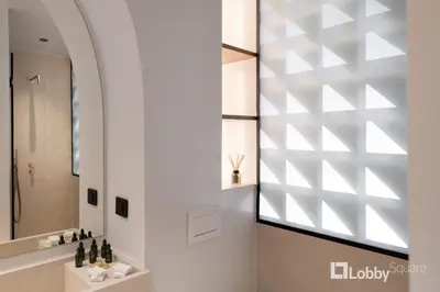 a bathroom with a large mirror and a sink at Muse Apartment by LobbySquare in Athens