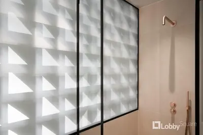 a glass shower door in a bathroom at Muse Apartment by LobbySquare in Athens