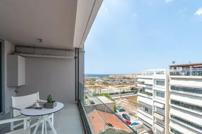 a balcony with a table and a view of a city at CW Athens Riviera Suite in Athens