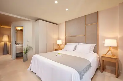 a bedroom with a large white bed and two lamps at CW Athens Riviera Suite in Athens