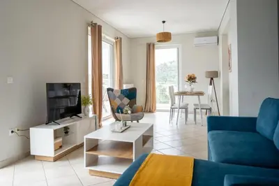 a living room with a blue couch and a table at Breathtaking view apartment in Glyfada (AS_D1) in Athens