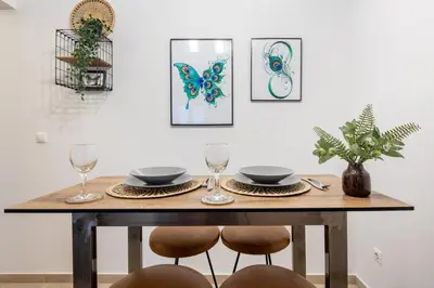 a dining room table with two chairs and two wine glasses at Zappa 2-Bedroom Apartment in Athens in Athens