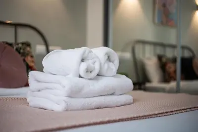 a pile of towels sitting on top of a bed at Zappa 2-Bedroom Apartment in Athens in Athens
