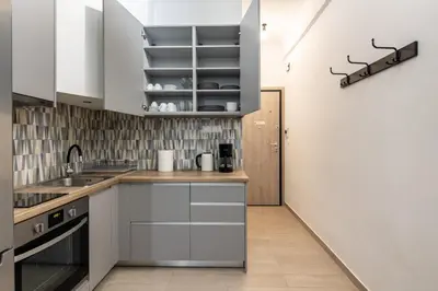 a kitchen with white cabinets and stainless steel appliances at Zappa 2-Bedroom Apartment in Athens in Athens