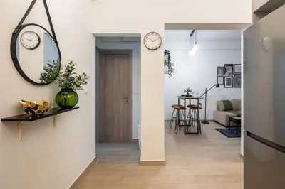 a living room with a hallway with clocks on the walls at Zappa 2-Bedroom Apartment in Athens in Athens