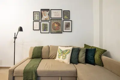 a couch in a living room with pictures on the wall at Zappa 2-Bedroom Apartment in Athens in Athens