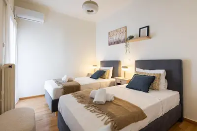 two beds in a room with white and blue at Zephyr 3-Bedroom Apartment in Athens in Athens