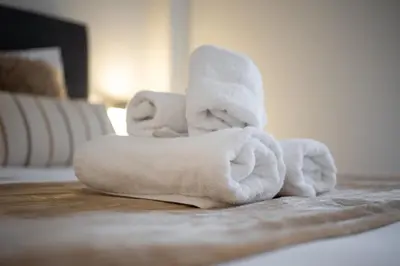a pile of towels sitting on a bed at Zephyr 3-Bedroom Apartment in Athens in Athens