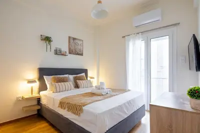 a bedroom with a large bed and a window at Zephyr 3-Bedroom Apartment in Athens in Athens