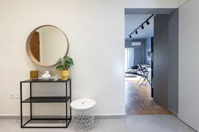 a hallway with a mirror and a table with a stool at Zephyr 3-Bedroom Apartment in Athens in Athens