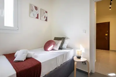 a white bedroom with a bed with pillows on it at Zephyr 3-Bedroom Apartment in Athens in Athens