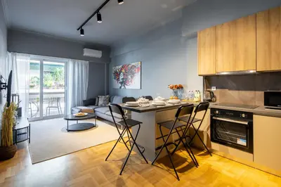 a kitchen and living room with a table and chairs at Zephyr 3-Bedroom Apartment in Athens in Athens