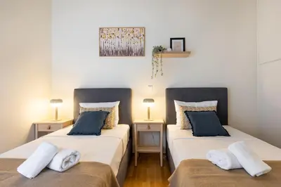 two beds sitting next to each other in a room at Zephyr 3-Bedroom Apartment in Athens in Athens
