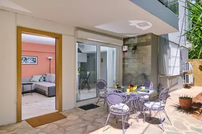 a patio with a table and chairs and a couch at Gly3 65m2 sunshine oasis in Glyfada in Athens
