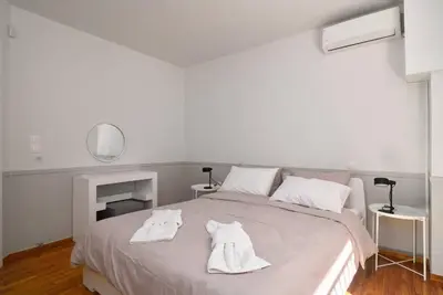 a white bedroom with a bed with white towels on it at Gly3 65m2 sunshine oasis in Glyfada in Athens