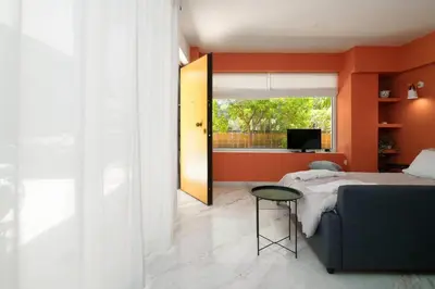 a bedroom with orange walls and a bed and a table at Gly3 65m2 sunshine oasis in Glyfada in Athens