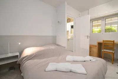 a white bedroom with two white towels on a bed at Gly3 65m2 sunshine oasis in Glyfada in Athens