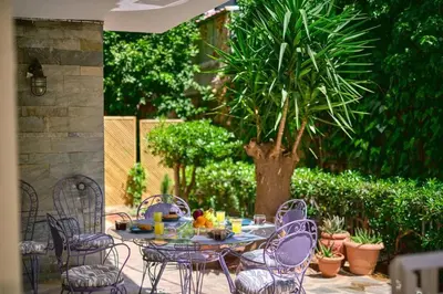 a table and chairs sitting on a patio with a tree at Gly3 65m2 sunshine oasis in Glyfada in Athens