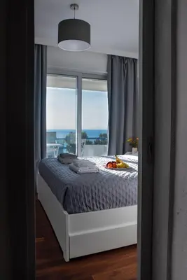 a bedroom with a bed with a view of a window at Traditional Seaview Maisonette in Saronida
